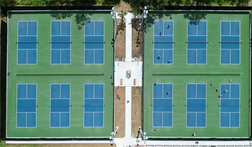 there are 12 pickleball courts and some people are playing 