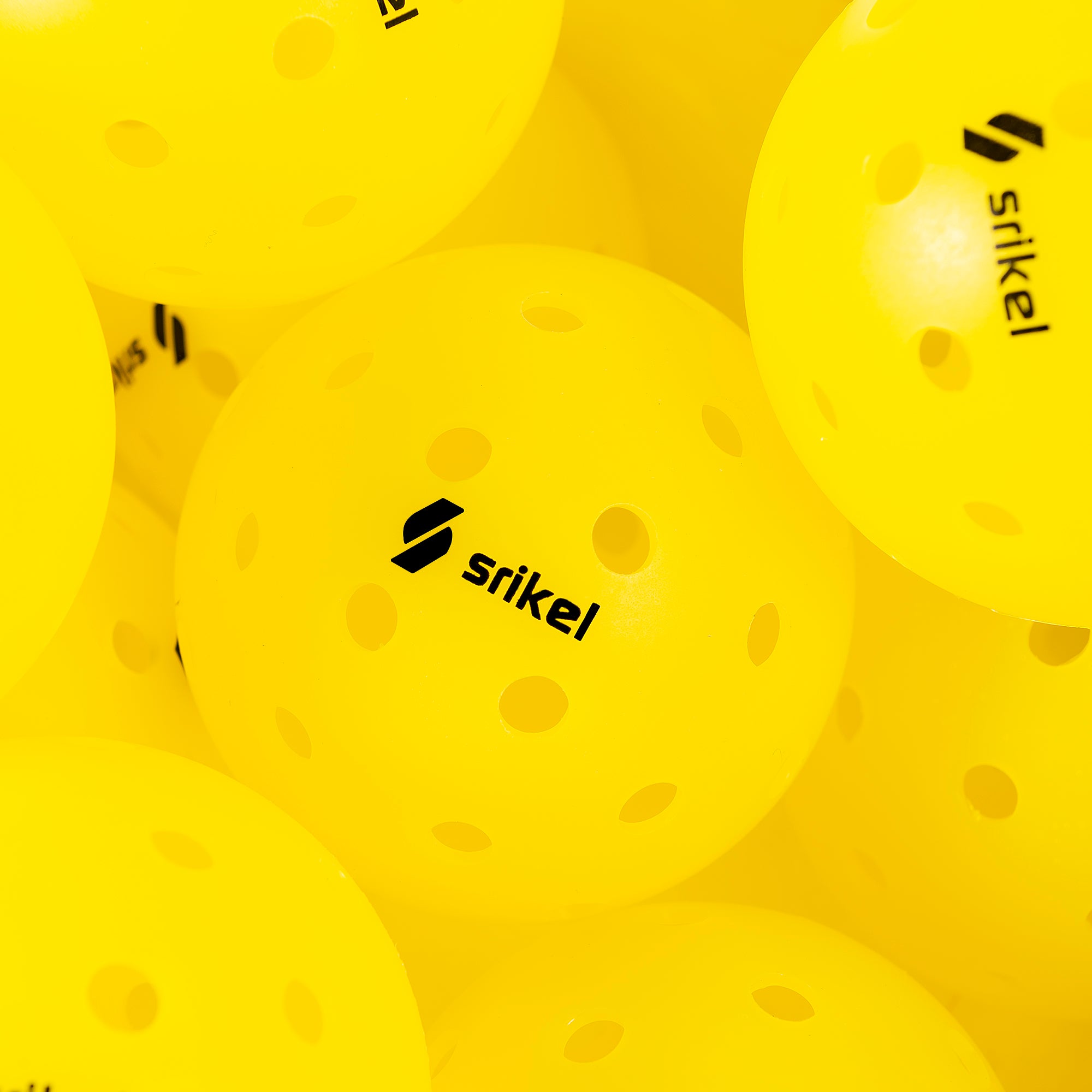 Multiple yellow Strikel XS-40 Outdoor Pickleball Balls are grouped together